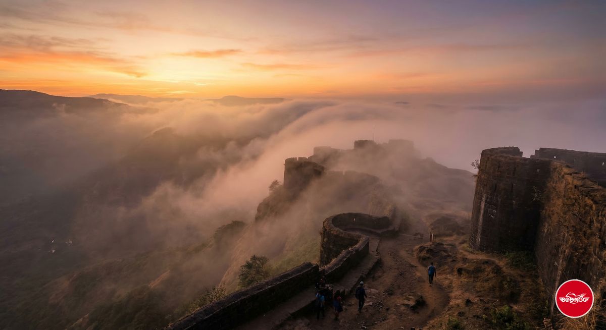 Sinhagad Fort hilltop with morning mist rising over valleys and ancient stone fortification walls near Pune