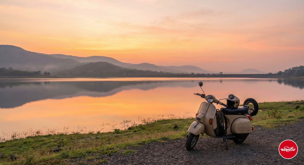 Sunrise over Khadakwasla Dam lake near Pune with calm water reflecting orange sky and a scooty parked at the edge