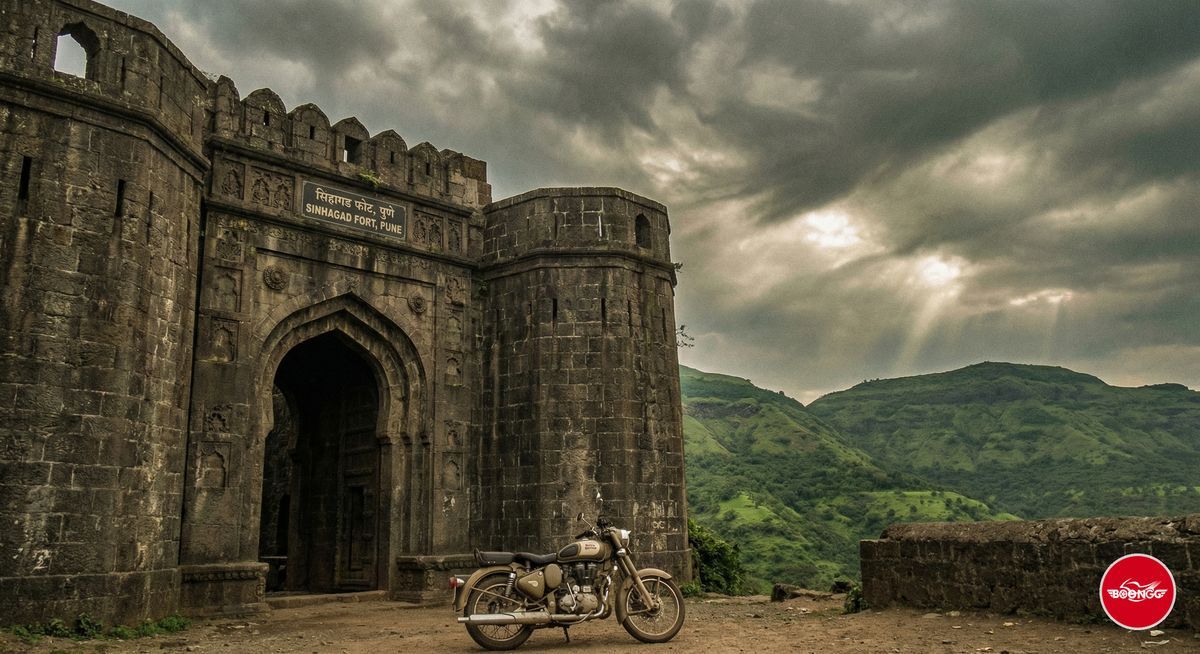 Sinhagad Fort stone entrance gate with green hills near Pune